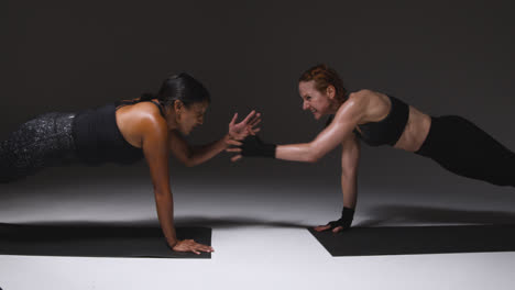 Foto-De-Estudio-De-Dos-Mujeres-Maduras-Vistiendo-Ropa-De-Gimnasio-Haciendo-Ejercicio-De-Tabla-Juntas-1